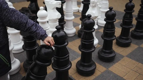 The kid plays big chess outside Stock Footage 110795381