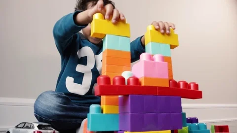 A Kid Plays With Blocks And Makes Sounds Видео 84141762