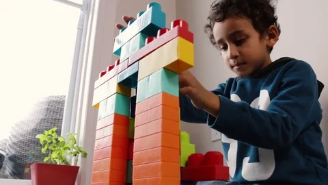A Kid Plays With Blocks And Makes Sounds With Window Stock Footage 84141767