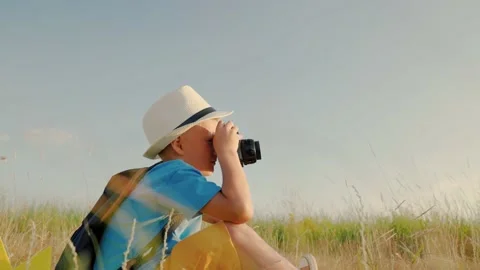 The kid plays with the camera in the summer park. Concept of childish fantasy in Vídeo Stock 166868138