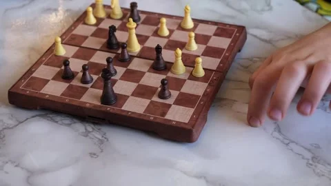 Kid plays chess and moves her fingers while thinking and deciding the next move Stock-Footage 256376145
