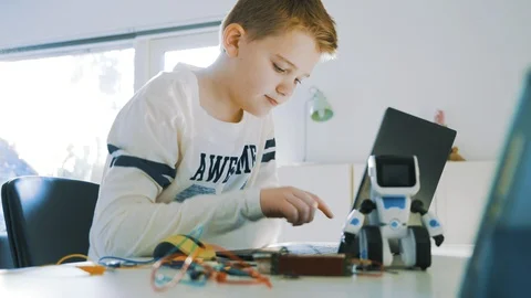 Kid plays with computer and electronics and start to type on the keyboard Stock Footage 102176776