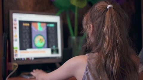 A kid plays a computer game on a computer Stock Footage 106957311