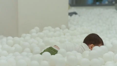 Kid plays in a dry pool with balls. Little boy playing in the pool with plastic Stock-Footage 266053875