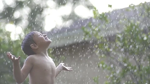 Kid plays in rain Stock Footage 97899849