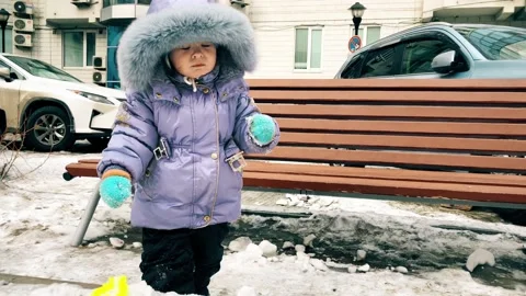 Kid plays in the sandbox in winter Stock Footage 148128642