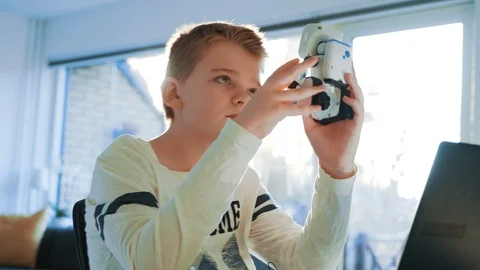 Kid plays with a small robot and day dreams as the sun shines through windows Stock Footage 102182160