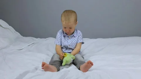The kid plays a toy on a gray background Stock Footage 132664001