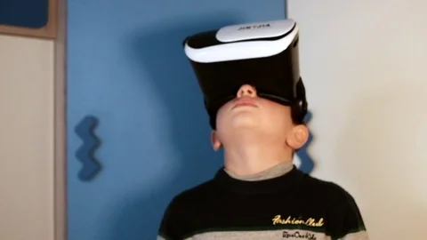 A kid plays virtual augmented reality game using head mounted display by usin Stock Footage 83881768