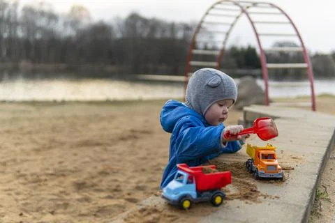 The kid pours sand into the machine. Stock Photos