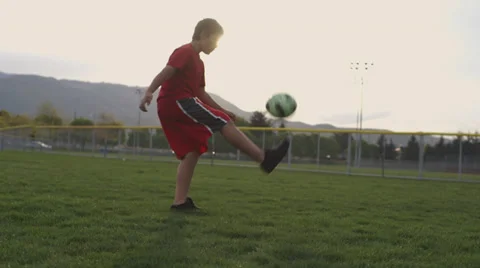 Kid practicing with soccer ball in sunshine Stock Footage 37408240