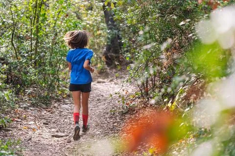 Kid practicing trail running in the forest Stock Photos
