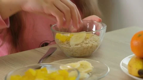 Kid Preparing Cereal with Fruit Stock Footage 316769140