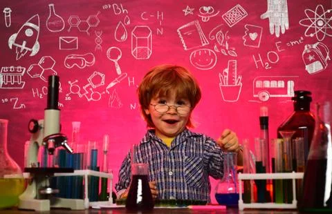 Kid from primary school. Lab microscope and testing tubes. First grade. Back to Stock Photos