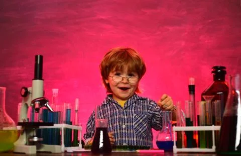 Kid from primary school. Lab microscope and testing tubes. First grade. Back to Stock Photos