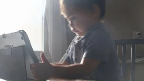Kid pulls tablet in toward him, video Stockbeeldmateriaal 79720284