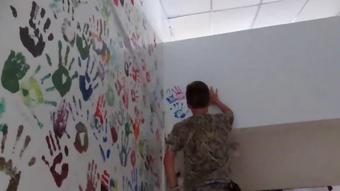 Kid putting handprints on the wall using paint Stock Footage 111234056