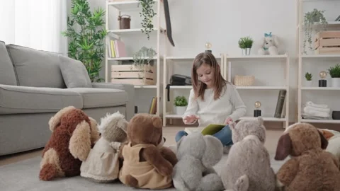 Kid reading a book to bunch of soft toys Stock Footage 235309041