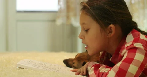 Kid reading a book with a dog Stock Footage 56768763