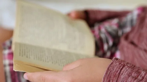 Kid reading paper book with interest laying in his bed at home. 스톡 동영상 84786935