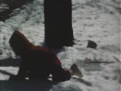Kid in red snowsuit crawling in the snow Stock Footage 79065702