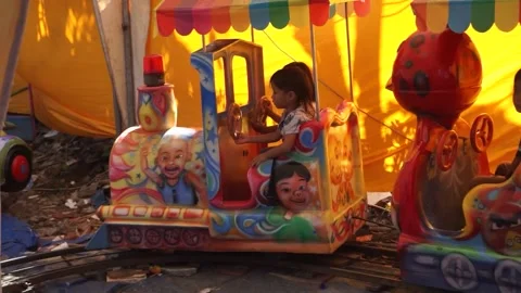 The kid rides on a train in the playground. Train goes on rails. 動画素材 204973119