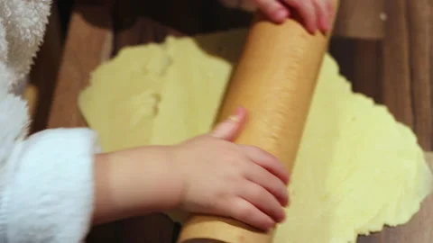 Kid with a rolling pin during baking cookies Stock Footage 239065570