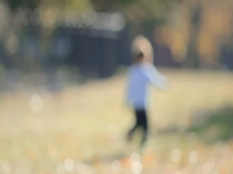 Kid is running in the fall city park laughing and playing in slow motion. Stock Footage 74006576