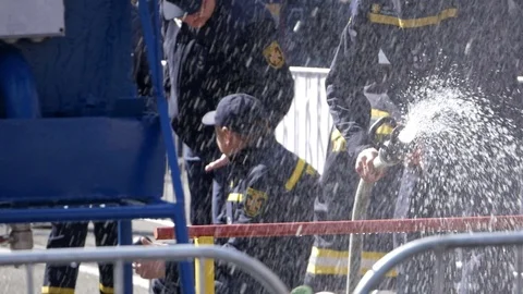 Kid runs away after using fire hose at firefighter festival in Kyiv Stockbeeldmateriaal 116381444