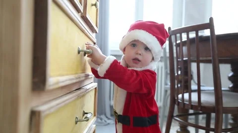Kid Santa suit trying open chest drawer wardrobe Stock Footage 81810688