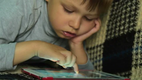 Kid searching for game on digital tablet Stock Footage 87160697
