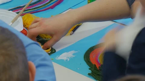 Kid is Separating a Pieces Cotton to Glue it Blue Paper Clouds to a Sky Kids' Stock Footage 61229273