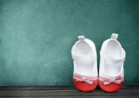 Kid shoes on schooltable Photos