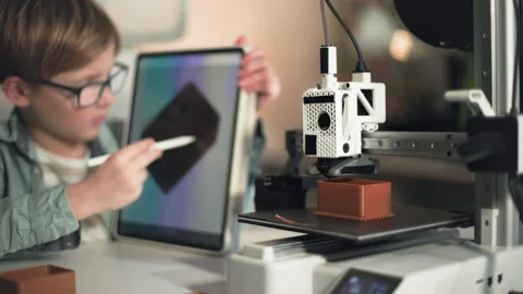 Kid on the shot, operate on the tablet and 3D printer on the foreground Stock Footage 335379993