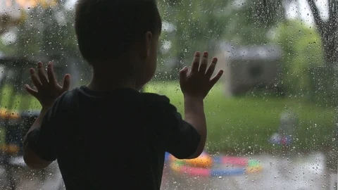 Kid singing and looking at the rain outside, video Video stock 77552161