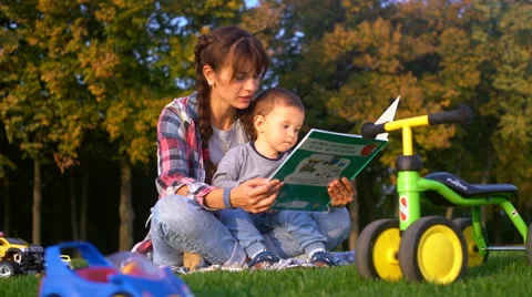 The Kid Sits at Mum on Hands and Looks Book Stock Footage 68102180