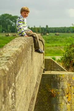 Kid sitting on bridge Stock Photos