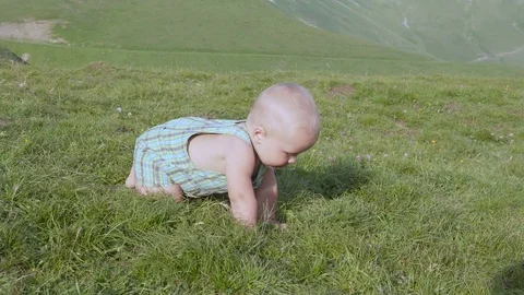 The kid is sitting on a hill 4k Stock Footage 80355214