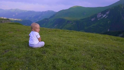 The kid is sitting on a hill Stock Footage 80368186