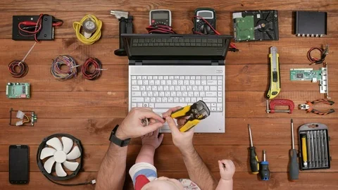 Kid sitting with his father as an engineer at the workplace. Man cuts off a Stock Footage 72424511