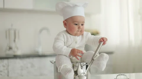 Kid sitting in a pot with a ladle Stock Footage 23740819