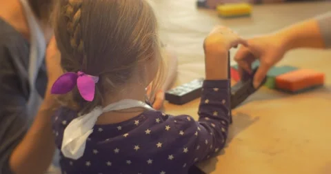 Kid Sitting at the Table Plays With Rubber Stamps Letters on the Table Woman Stock Footage 60404130