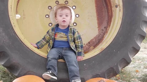 Kid Sitting in a Tractor Tire Stock Footage 145516652