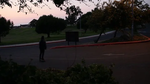 Kid skateboards down hill in parking lot Stock Footage 102827641
