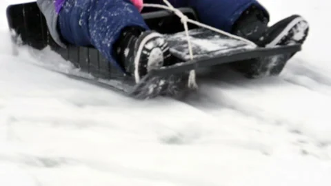 Kid on sled sliding down snow covers hill in slow motion sledding Video stock 151002658