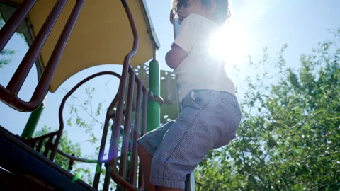 Kid slides down from playground metal pole during beautiful sunny day at ci.. Vídeo Stock 222953710