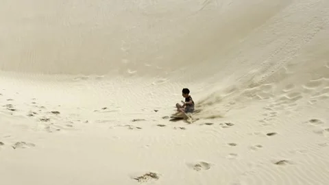 Kid sliding down sand dune in viana desert, cape verde Stock Footage 302566555