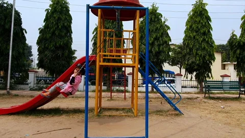 Kid small playing in park on swing ringing enjoying in Jammu and Kashmir duri Stock Footage 144825164
