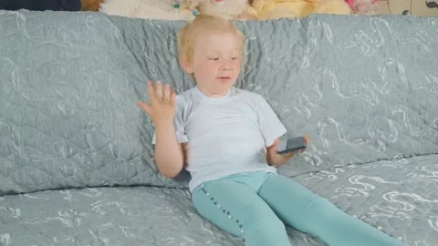 The kid smiles and clowns while sitting at home Stock Footage 134444135