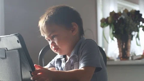 Kid smiling and watching tablet, video Stock Footage 79720438